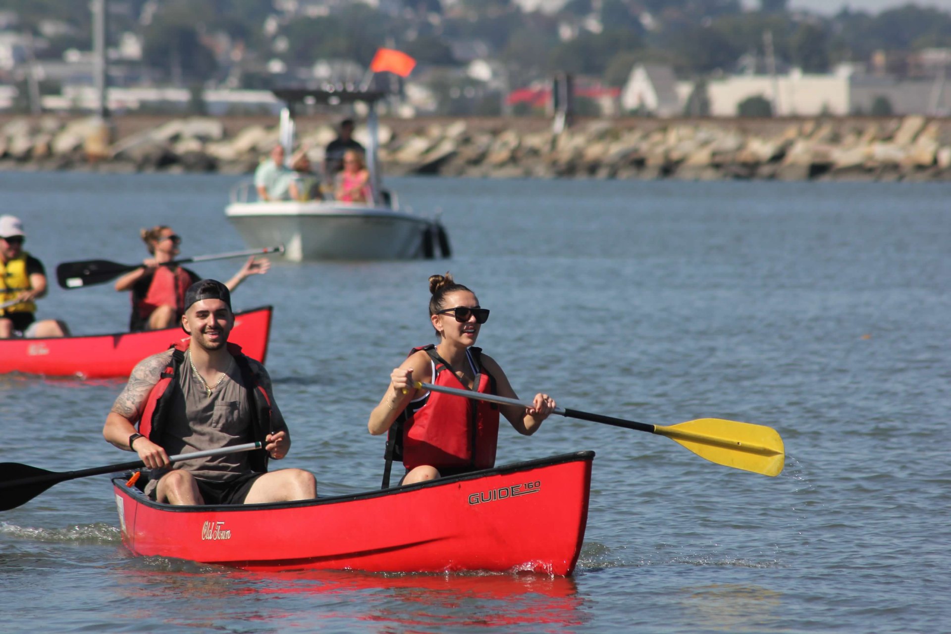 Teammates paddling a red canoe